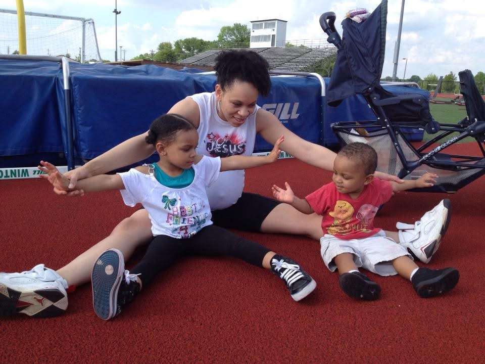 Tara stretching with the kids on the track